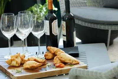 a table with glasses of wine and food on it at Kimpton Surfcomber Hotel by IHG in Miami Beach