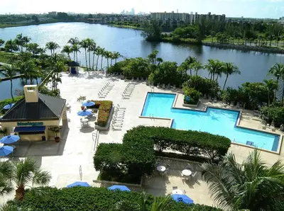 an aerial view of a resort with two pools and umbrellas at Hilton Miami Airport Blue Lagoon in Miami