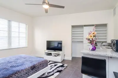 a bedroom with a bed and a flat screen tv at Ocean Drive Studio Historic Building minutes walk to the Beach. in Miami Beach