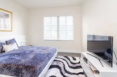 a bedroom with a bed and a flat screen tv at Ocean Drive Studio Historic Building minutes walk to the Beach. in Miami Beach