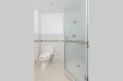 a bathroom with a toilet and a glass shower at Ocean Drive Studio Historic Building minutes walk to the Beach. in Miami Beach