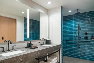 a bathroom with two sinks and a shower at The Dalmar, Fort Lauderdale, a Tribute Portfolio Hotel in Fort Lauderdale