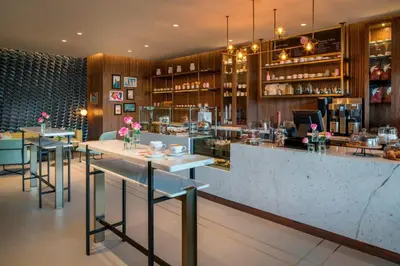 a bar with tables and chairs in a restaurant at The Dalmar, Fort Lauderdale, a Tribute Portfolio Hotel in Fort Lauderdale