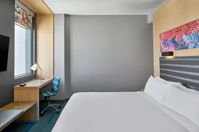 a hotel room with a bed and a desk at Aloft Miami Aventura in Aventura