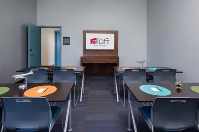 a classroom with tables and chairs and a piano at Aloft Miami Aventura in Aventura