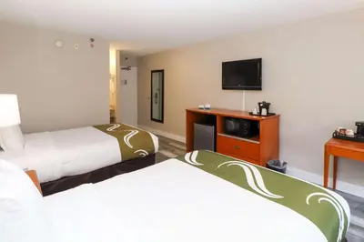 a hotel room with two beds and a flat screen tv at Quality Inn Miami Airport - Doral in Miami