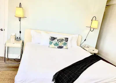 a bedroom with a white bed with two lamps at Broadmore Miami Beach in Miami Beach