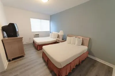 a hotel room with two beds and a tv at Broadmore Miami Beach in Miami Beach