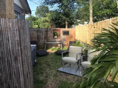 a backyard with two chairs and a table and a fence at INN LEATHER GUEST HOUSE-GAY MALE ONLY in Fort Lauderdale
