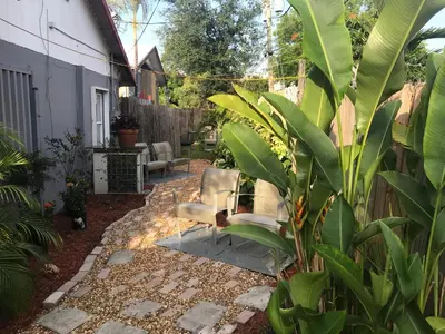 a patio with two chairs in a garden at INN LEATHER GUEST HOUSE-GAY MALE ONLY in Fort Lauderdale