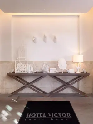 a room with a table with a hotel voodooulumulumulum at Hotel Victor South Beach in Miami Beach