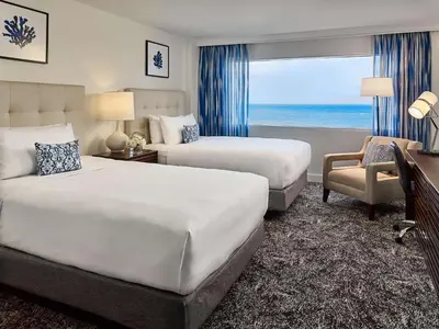 a hotel room with two beds and a window at Sonesta Fort Lauderdale Beach in Fort Lauderdale