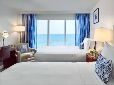 a hotel room with two beds and a view of the ocean at Sonesta Fort Lauderdale Beach in Fort Lauderdale