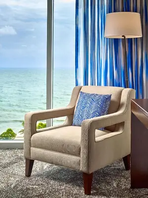 a chair in front of a window with the ocean at Sonesta Fort Lauderdale Beach in Fort Lauderdale