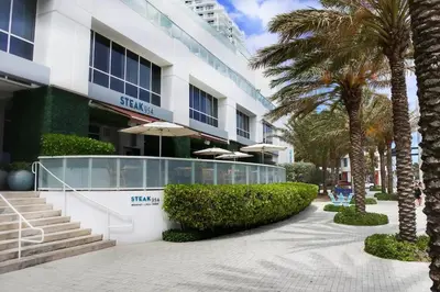 a building with palm trees in front of it at 1201 W Residences in Fort Lauderdale
