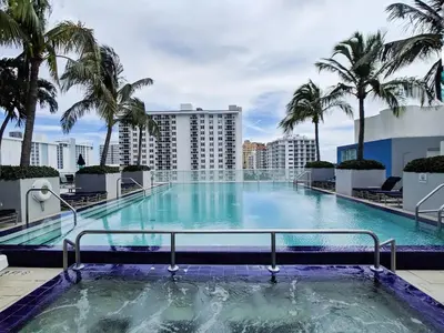 a large swimming pool on the roof of a building with palm trees at 1201 W Residences in Fort Lauderdale