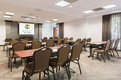 a conference room with tables and chairs and a screen at Hyatt Place Ft. Lauderdale/Plantation in Plantation