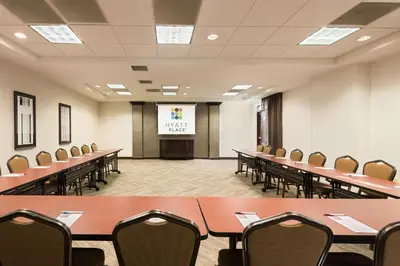 a conference room with tables and chairs and a screen at Hyatt Place Ft. Lauderdale/Plantation in Plantation