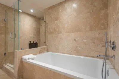 a bathroom with a tub and a glass shower at Oceanview Private Condo at 1 Hotel & Homes -915 in Miami Beach