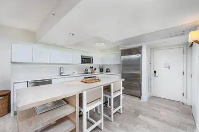 a kitchen with white cabinets and a wooden counter top at Oceanview Private Condo at 1 Hotel & Homes -1208 in Miami Beach