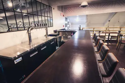 a bar in a restaurant with a sink and chairs at enVision Hotel Miami International Airport in Miami