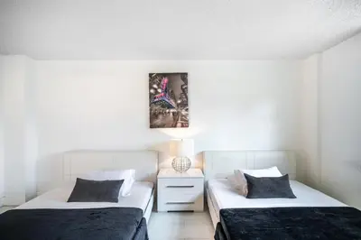 two beds in a room with white walls at Sunny Isles Ocean Reserve Superb Condo Apartments in Miami Beach