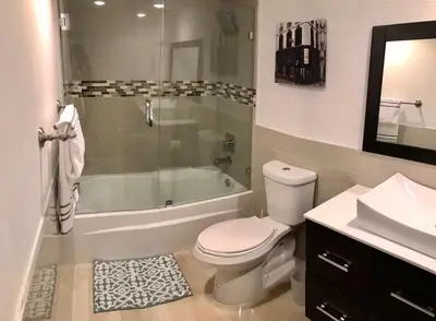 a bathroom with a toilet and a tub and a sink at Sunny Isles Ocean Reserve Condo Apartments in Miami Beach