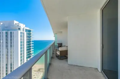 a room with a balcony with a view of the ocean at 2 Bedroom on 17th floor on the beach Resort in Hallandale Beach