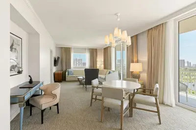 a living room with a table and chairs in a hotel room at JW Marriott Miami Turnberry Resort & Spa in Aventura