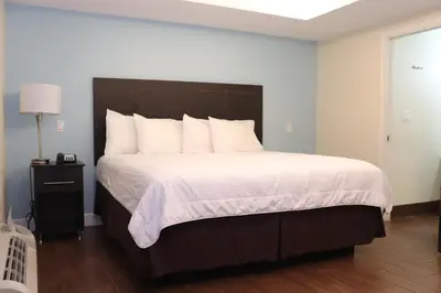 a bedroom with a large bed with white sheets and pillows at Curtis Inn & Suites in Hollywood