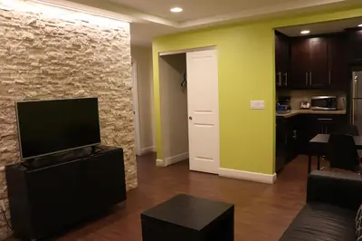 a living room with a flat screen tv on a stone wall at Curtis Inn & Suites in Hollywood