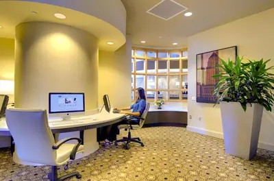 a woman sitting at a desk in an office with a computer at Hampton Inn & Suites by Hilton Miami Downtown/Brickell in Miami