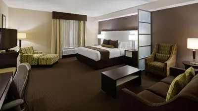 a hotel room with a bed and a living room at Best Western Plus Miami Intl Airport Hotel & Suites Coral Gables in Miami