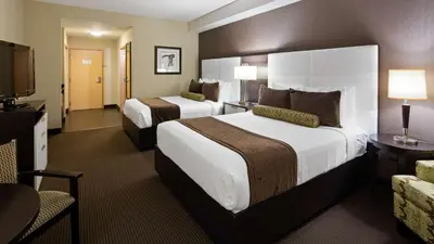 a hotel room with two beds and a flat screen tv at Best Western Plus Miami Intl Airport Hotel & Suites Coral Gables in Miami