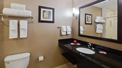 a bathroom with a sink and a toilet and a mirror at Best Western Plus Miami Intl Airport Hotel & Suites Coral Gables in Miami