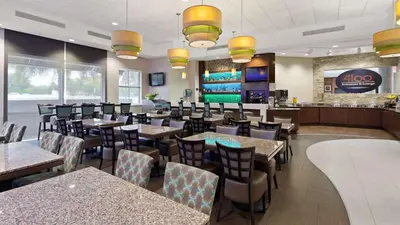 a restaurant with tables and chairs and a bar at Best Western Plus Miami Intl Airport Hotel & Suites Coral Gables in Miami
