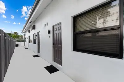 a white building with a pair of doors on it at Modern Loft wQueen Loft Steps to Beach in Hollywood