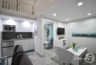 a kitchen with a living room with a couch and a table at Modern Loft wQueen Loft Steps to Beach in Hollywood