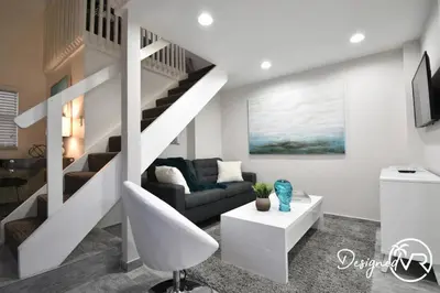 a living room with a staircase and a couch at Modern Loft wBed Steps from Beach Boardwalk in Hollywood