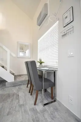 a dining room with a glass table and a chair at Modern loft wqueen bed steps to beach in Hollywood