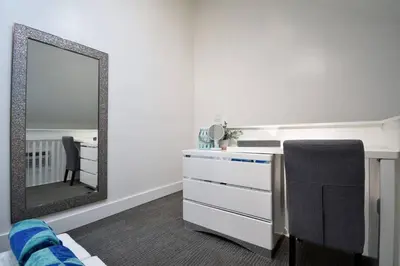 a bedroom with a mirror and a desk with a chair at Modern loft wqueen bed steps to beach in Hollywood