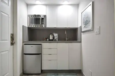 a kitchen with white cabinets and a microwave at Modern Loft wQueen Loft Steps to Beach in Hollywood