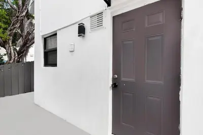 a gray door in a white wall with a house at Loft wqueen bed steps to Hollywood Beach in Hollywood
