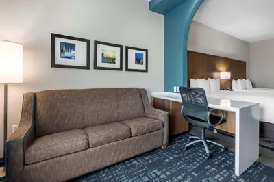 a hotel room with a couch and a bed at Comfort Suites Fort Lauderdale Airport & Cruise Port in Dania Beach