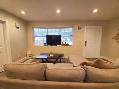 a living room with a large couch and a tv at Lakefront Vacation Home - Sleeps 8 in Davie