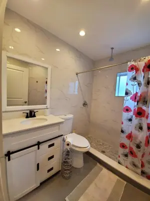 a bathroom with a toilet and a sink and a mirror at Lakefront Vacation Home - Sleeps 8 in Davie