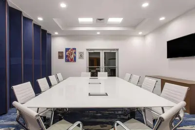 a conference room with a large white table and chairs at Maritime Hotel Fort Lauderdale Airport & Cruiseport in Fort Lauderdale
