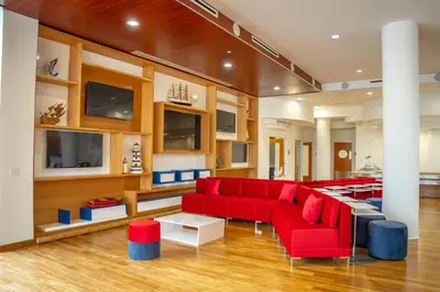 a living room with red couches and a table at Maritime Hotel Fort Lauderdale Airport & Cruiseport in Fort Lauderdale