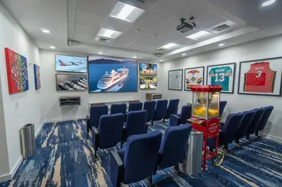 a waiting room with blue chairs and a large screen at Maritime Hotel Fort Lauderdale Airport & Cruiseport in Fort Lauderdale