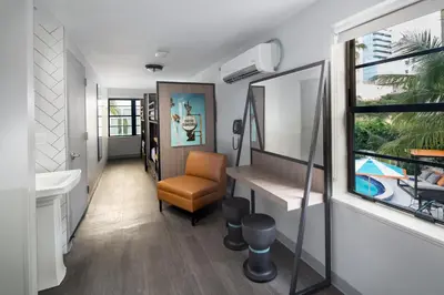 a bathroom with a desk and a chair and a window at Generator Miami in Miami Beach